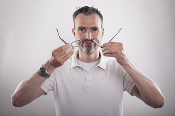 Kurzsichtiger Mann zeigt ein zerbrochenes Brillengestell