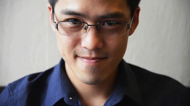 Portrait of Handsome Chinese-Thai  Asian male in dark blue shirt with smile face looking at camera