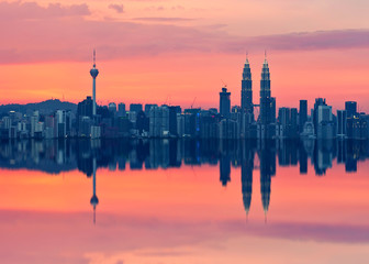 Scenic view of Kuala Lumpur city skyline in sillhoute with full reflection.