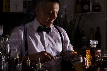 Young man working as a bartender in a nightclub/cocktail bar
