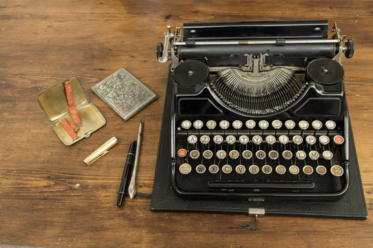 Macchina da scrivere e penna stilografica con due  antichi portasigarette, strumenti di lavoro del giornalista degli anni venti