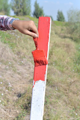Painting red colour the pole with brush