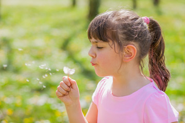 Child blowing dandelion