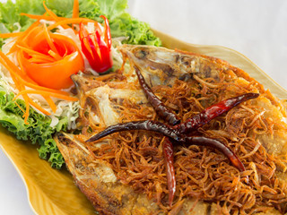 Fried fish topped with chili, vegetable dish.