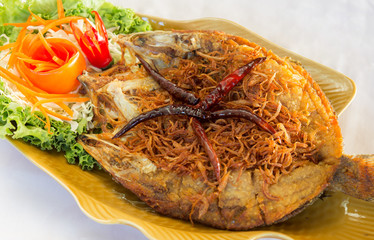Fried fish topped with chili, vegetable dish.