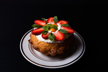 Fresh cake with cream and berries on black background
