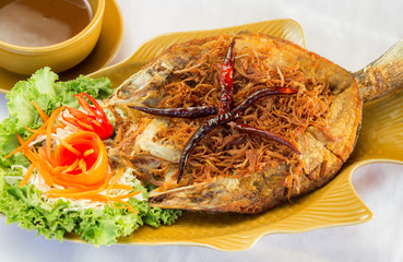 Fried fish topped with chili, vegetable dish.