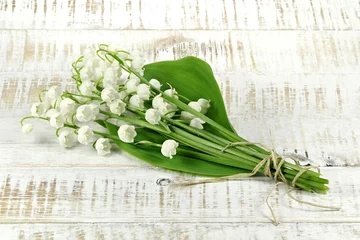 Fotobehang bunch of lily-of-the-valley on wooden background © Björn Wylezich