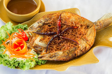 Fried fish topped with chili, vegetable dish.