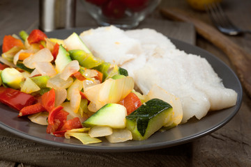 cut vegetables and grilled fish in classic wood