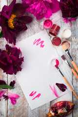 Fototapeta na wymiar Workspace. Watercolor, paintbrush and pink peonies isolated on white background. Overhead view. Flat lay, top view