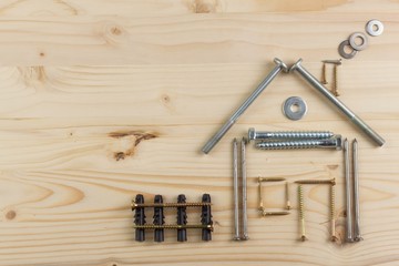 Building a house for the family. Plans to build a small house. Architect designing a house for a young family. House from nails and screws. Needed for building. Ideas about building a house.

