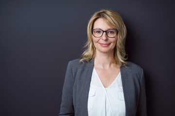 lächelnde blonde frau vor grauem hintergrund