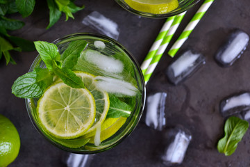 Mojito cocktail on black background with mint and lime