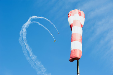 Two single-engine airplane in the sky draw a loop out of clouds on background wind direction