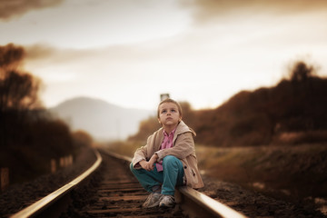 Fototapeta na wymiar boy sitting on the railroad