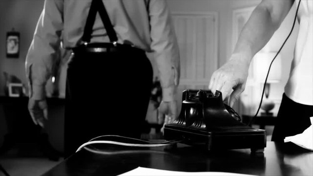 A scene set in the 1940's of a woman making a phone call from a vintage rotary phone while a man walks past her puts on his fedora and coat and exits the scene. Black and White  Film Noir Genre
