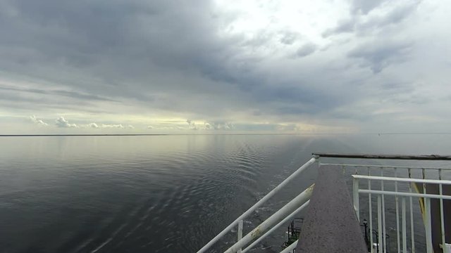 Backdrop of moody sky in the evening with still water on a boat deck
