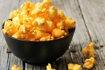 Cheese popcorn in a black bowl, selective focus