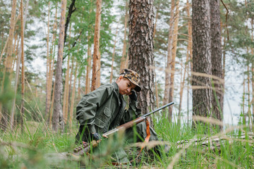 Woman hunter with a gun. Hunting in the woods.