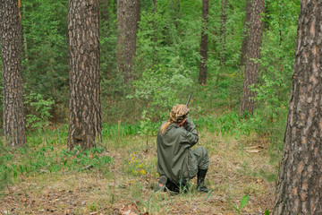Naklejka na ściany i meble Woman hunter with a gun. Hunting in the woods.