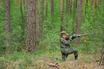 Woman hunter with a gun. Hunting in the woods.