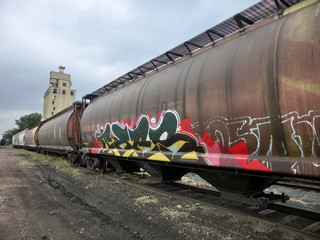 Fototapeta na wymiar Industrial urban weathered rusty train with painted graffiti