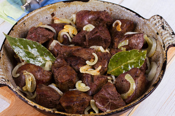 Sauteed liver with onions in pan.
