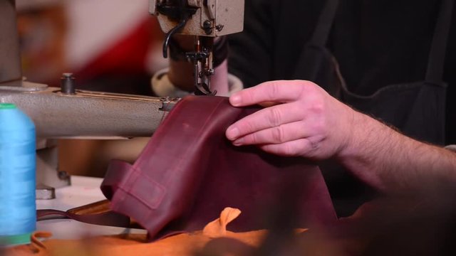 Leather goods craftsman at work in his workshop, France-Sewing machine and reels son