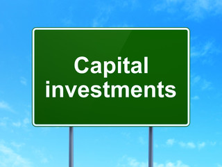 Currency concept: Capital Investments on road sign background