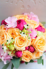 Beauty of colored flowers. Bridal accessories. Close-up bunch of florets. Details for marriage and for married couple. Wedding bouquet with roses and orchids on the white background
