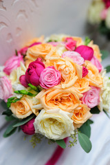 Beauty of colored flowers. Bridal accessories. Close-up bunch of florets. Details for marriage and for married couple. Wedding bouquet with roses and orchids on the white background