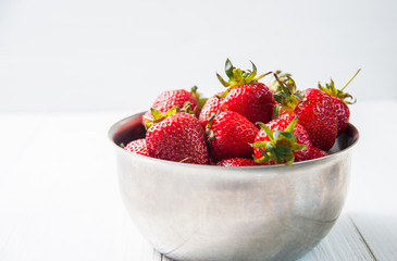 Fresh strawberries on white wooden background