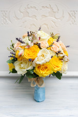 Beauty of yellow flowers. Bridal accessories. Close-up bunch of florets. Details for marriage and for married couple. Wedding bouquet with yellow roses and ribbons