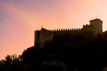 Silhouette of a castle on a mountain in the sunset.Italy, Angera. Castle Rocca di Angera. Toning