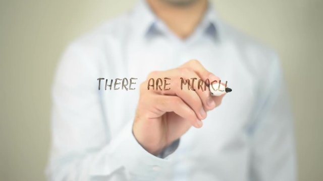 There Are Miracles All Around you, man writing on transparent screen