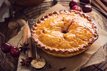 Cherry pie on rustic background