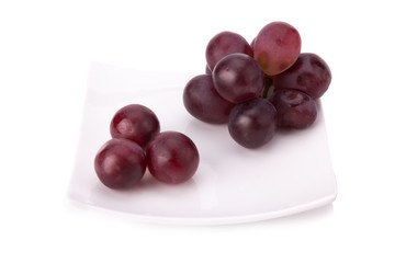 Ripe red grape with leaves isolated on white