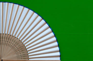 Typical Japanese hand fan made on the wooden green desk