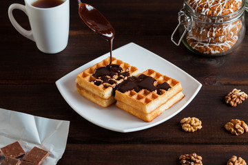Belgium waffles with melted chocolate and walnuts.