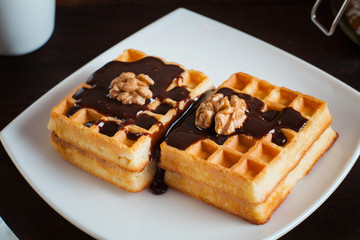 Belgium waffles with melted chocolate and walnuts.