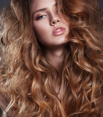 Vogue style photo of sensual woman with long curly hair.