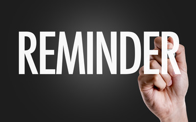 Hand writing the text: Reminder