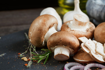 Button mushroom with rosemary, onion and peppercorns. Still life