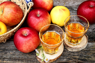 Apple juice in two glass on old wooden table