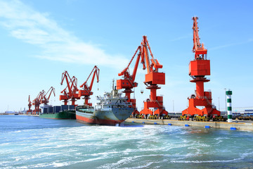 In freight terminal, gantry crane and cargo ships are in loading