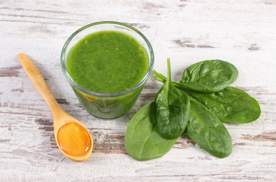 Cocktail from spinach with honey on old rustic wooden background, healthy nutrition