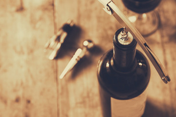 top view image of red wine bottle and corkscrew