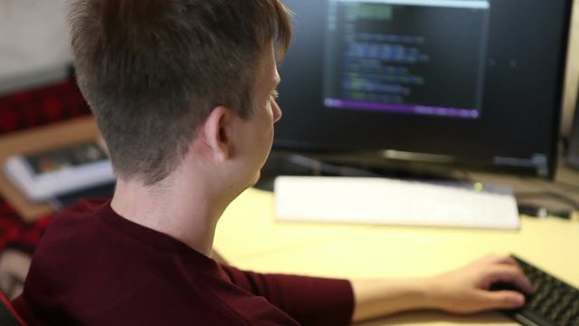 Freelance programmer writes a program while sitting at the computer