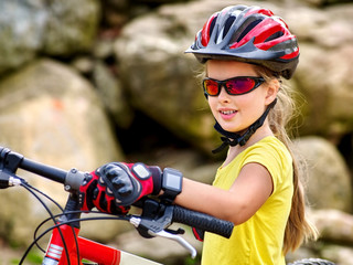 Bikes bicyclist girl. Girl with  smart watch rides bicycle into mountains. Girl wearing helmet and gloves on bicycle in mountaineering  . Mountaineering  is good for health.  - 111643225